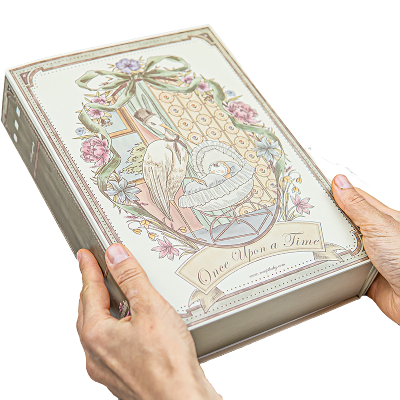 Home 1 A personalised Rompibaby keepsake baby hamper in its storybook gift box, held in two hands